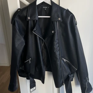 Svart Skinnjacka - Skinnjacka från Missguided. Storlek M, sitter oversize på mig som har S i vanliga fall. Använd fåtal gånger så mycket fint skick! Tyvärr har grejen på dragkedjan åkt av, men jag personligen stänger aldrig dragkedjan på skinnjackor ändå :) 166 med frakt🤍