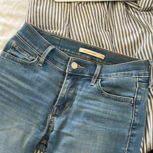Lågmidjade jeans - Ljusblå lågmidjade levis jeans i strl 26. Längden och modellen passar 175cm. Bra skick, dock slitningar i tyget som man trär in skärp. Frakt tillkommer INTE💕