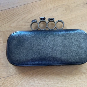 Väska clutch goth dödskalle  - Sjukt snygg och unik festväska som man har som ett knogjärn. Går att fästa en kedja på om man har en. Ingår ej! Ena klon på diamanten fattas. Inget som förr eller förstör. Från  River Island. Frakt ingår 