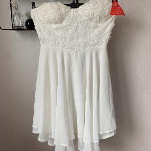 Oanvänd vit klänning med fina detaljer, fint fall med inbyggd bh. Stl 36.