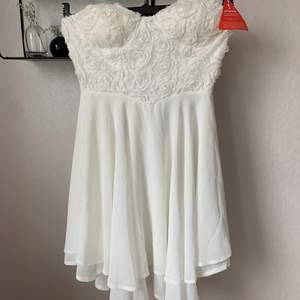 Oanvänd vit klänning med fina detaljer, fint fall med inbyggd bh. Stl 36.