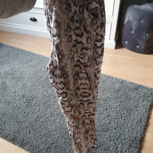 Svala byxor med resor i midjan, från HM st. 34 - Säljer ett par byxor i tunt material, fickor fram inga back. Orm print, från HM storlek 34. 