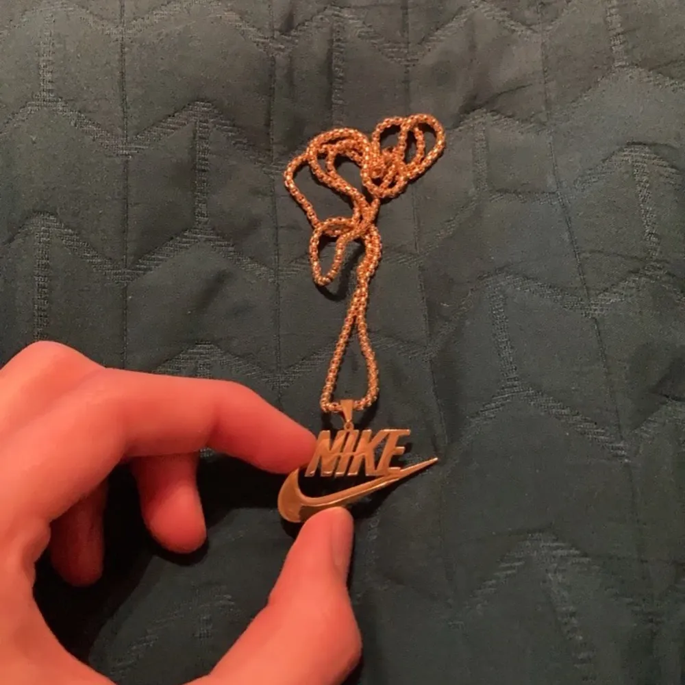 Ett Nike halsband i guldfärg med utsökt färg och kvalitetsmaterial 🥂. Accessoarer.