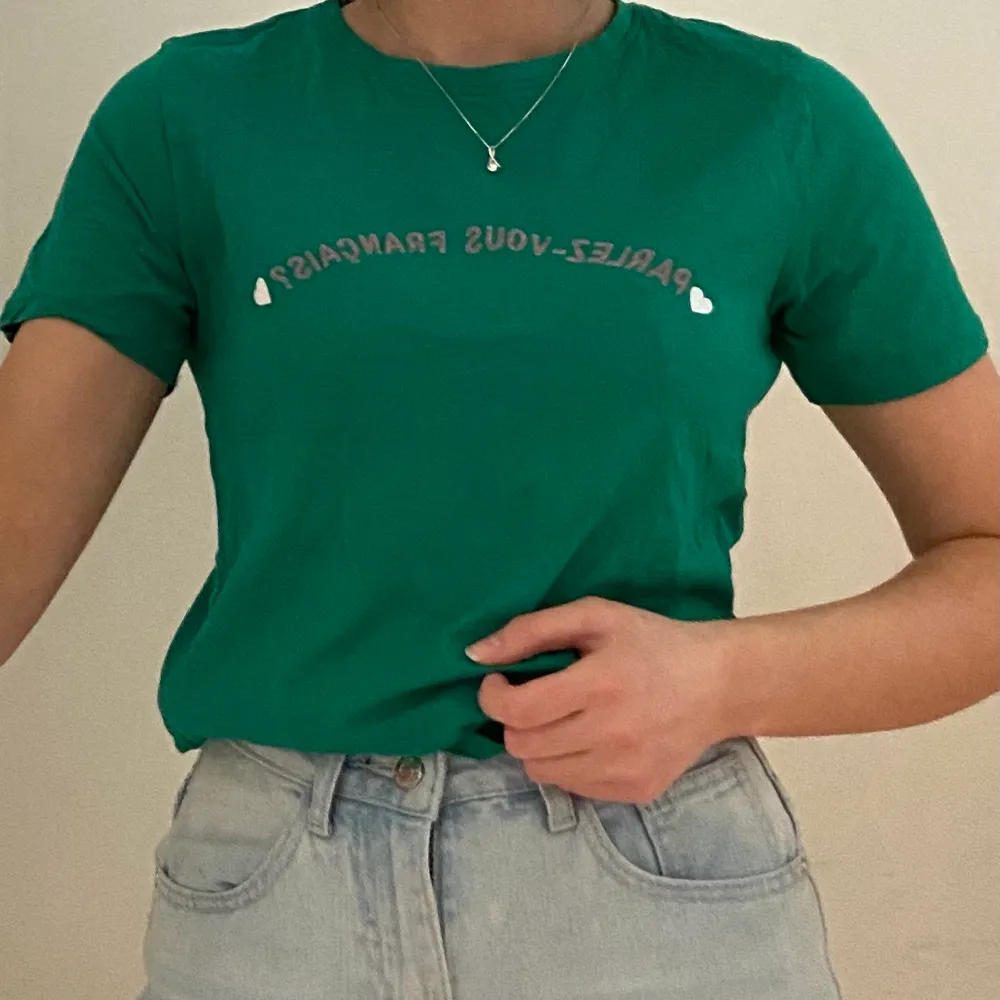 En skön mörkgrön t-shirt i storlek M. Rosa text på franska och vita hjärtan. Köpt i England och har haft den i några år men den är i bra skick. 100% bomull. Säljer pga att den inte används. Kan mötas i Umeå eller skicka om köpare står för frakt. Spårbar: 66kr, icke-spårbar: 30kr. T-shirts.