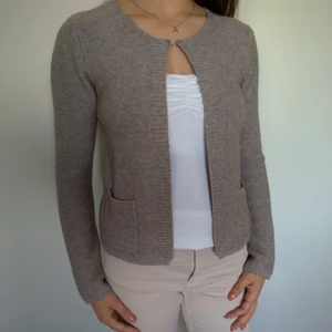 Stickad kofta  - En ljusbrun kofta i stickat stuk med en "krok-och-öga" stängning längst upp. Den har även två fickor. Perfekt att ha på en sen sommarkväll. Jag säljer den då den hängde i garderoben för länge utan att jag haft den på mig. Den är i nyskick. 