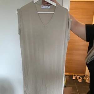 Beige snygg vadlång klänning med slits - En skön och snygg vadlång beige klänning som har slits på båda sidor nertill. Storlek small.