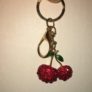 Nyckelring Körsbär - En körsbärsnycklring. Körsbäret är Ca. 3,5 cm och hela är Ca. 8,5 cm. Aldrig använd, iprincip nyskick. 