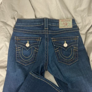 Trendiga True Religion Bootcut Jeans  - Säljer ett par jättesnygga lowwaisted jeans från True Religion i modellen ”Becky” som tyvärr inte har kommit till använding då de är förlånga för mig (jag är 155cm). Innerbenslängden är 85cm och de är stretchiga i materialet. Inga defekter förutom att dragkedjan är förstörd på ett ställe (som inte syns då det är på insidan) men den går att dra upp och ner ändå! Skriv för mer info❤️