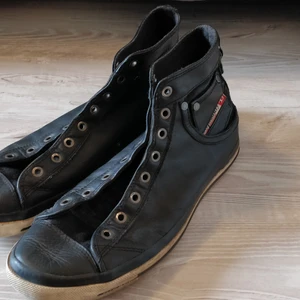 Diesel höga sneakers i läder - Diesel höga sneakers i läder. Bara använda en säsong och har sedan stått i min garderob i ett par år. I väldigt bra skick alltså. Mörkgrå. Storlek 43.