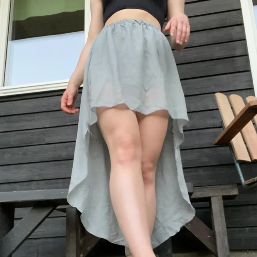 Finfin grå kjol i tunnt tyg. Säljer för att den aldrig kommer till användning, resor i midjan och tyget rör sig jättefint :). Kjolar.