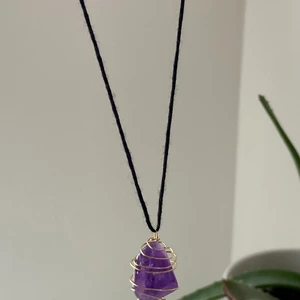 ametist kristall halsband  - äkta ametist kristian men metalltråd runt om och svart band som sätts ihop med en guld karbinhake. 