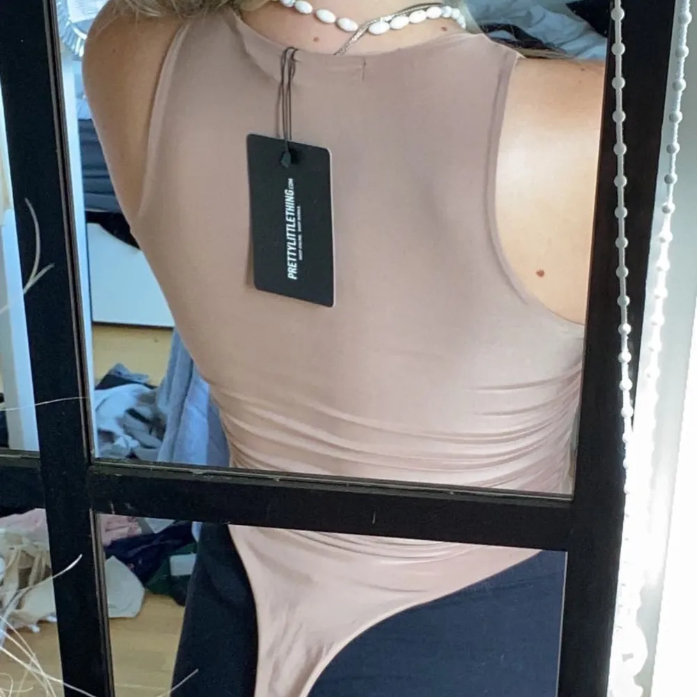 Fin beige body från prettylittlething. String modell, aldrig använd med prislapp kvar. ❣️. Toppar.