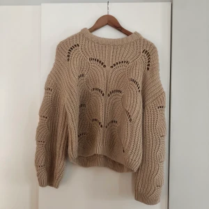 Stickad tröja strl L - Köpte denna tröja för ca 4 år sedan och har använt den endast ett par gånger. Supermysig med härliga, puffiga ärmar. Färgen är en blandning mellan ljusrosa och beige. 