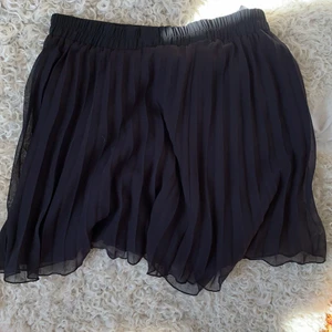 Monki Kjol strlk M - Säljer min plisserade monki kjol i svart som slutar  ovanför knäna på mig som är 167 cm! Kjolen är i bra skick och härlig nu under sommaren