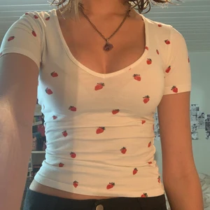 Söt tröja med jordgubbar - Söt vit urringad tröja med jordgubbar på. Den är tight och stretchig.