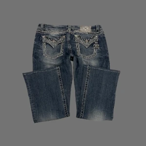 Lågmidjade Bootcut Miss Me jeans - OTROLIGT fina lågmidjade bootcut miss me jeans i storlek 34! 😍midjemåttet: 46cm innerbenslängd: 78cm PS; KOLLA IGENOM MITT KONTO NI KOMMER HITTA MÅNGA Y2K OCH VINTAGE PLAGG!