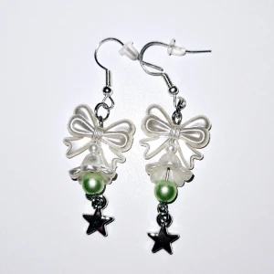 Grön med klocka - Vita akrylpärlor med vit akrylklocka med grön akrylpärla i och silvrig stjärna. Silvriga örhängen (ej äkta silver, ej nickelfria) 