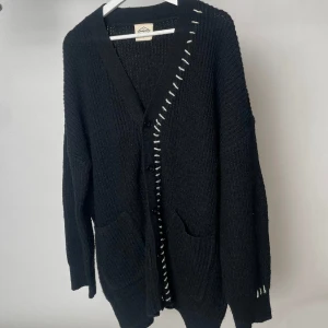 Stickad cardigan - Svart stickad cardigan med vita detaljer❤️‍🔥❤️‍🔥 Köpt i seoul och är från ett koreanskt märke🥹🥹🥹 så cool!!! Ca storlek M-L då jag inte fattar koreanska haha😄