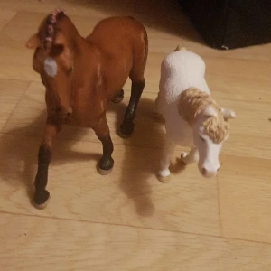schleich hästar - den vita kan inte stå på mator och den bruna har några flekar på sej