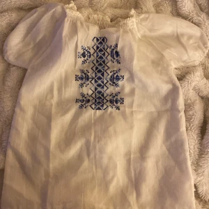 Blus med blåa detaljer - Säljer denna fina blus då den inte passar. Skulle säga att den passar någon som har rätt så smala armar, och lite mindre bröst då den inte har någon stretch 👐