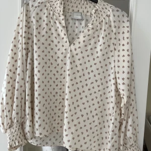 Blus och kjol (sommarset) - Blus och kjol från Neo Noir säljes tillsammans. Använda endast vid 1 tillfälle. Blusen har en pytteliten blå fläck efter en penna som knappt syns, framförallt inte när den är instoppad i kjolens linning.