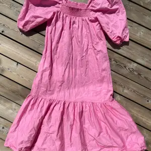 Drömklänningen från H&M storlek S En rosa smällkaramell med puffärmar  Long, A-line dress in a crisp organic cotton weave with smocking at the top. Square neckline with concealed elastication to keep the dress in place and wide, half-length sleeves 
