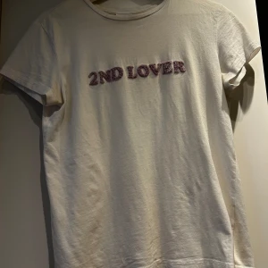 T-shirt från 2ndday - En vit t-shirt från 2ndday,står ingen storlek men skulle säga S men även M om man vill ha den lite mer åtsittande.   