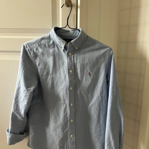 Ralph Lauren skjorta - Säljer en Ralph lauren skjorta som endast är använd ett fåtal gånger! Storleken är 14-16 år. Om det är något ni undrar så är bara att fråga.