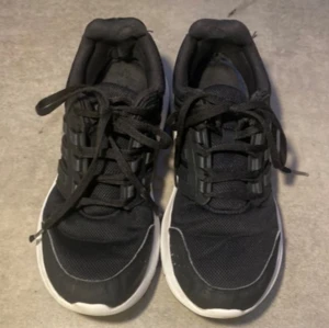 Adidas sneakers- svart - Svarta adidas sneakers med vita detaljer. Skorna är i mycket bra skick och är använda lite samt har några skavanker men är fortfarande fina.