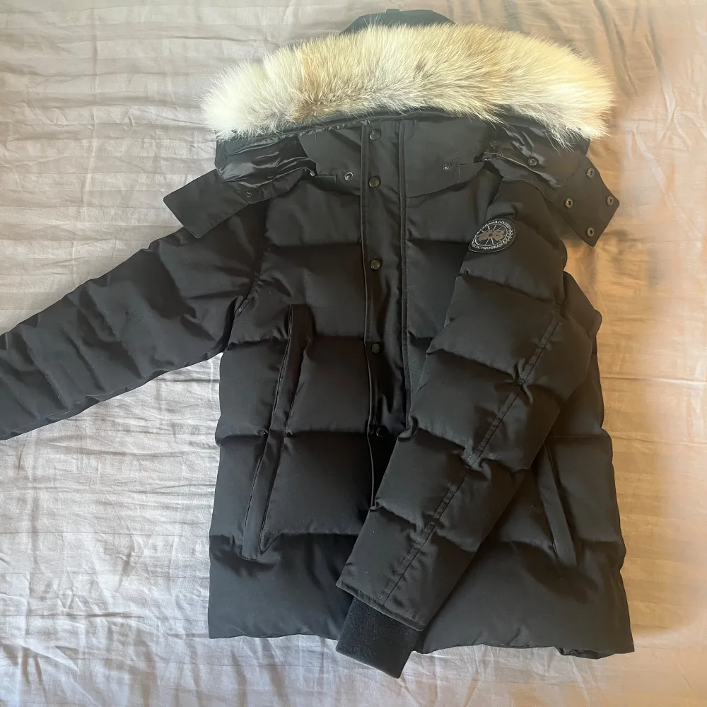 Svart Canada Goose Wyndham Black Label vinterjacka i mycket bra skick. Storlek: S. Använd ungefär två månader.  Skicka meddelande för fler bilder, eller vid intresse! Kvitto finns tyvärr ej men tags, och påsar finns. Inga byten!. Jackor.