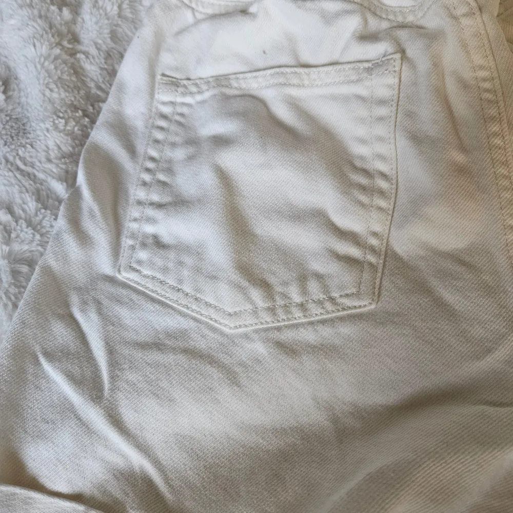 Vita högmidjade shorts med tillhörande skärp,dragkedja och knappar på shortsen och det är även resår i midjan. Fickor bak och fram. Strl 36. Katt finns I hemmet. Shorts.