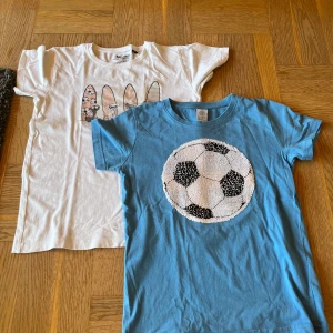 T-shirts  - Två stycken kortärmade tröjor. En blå med paljetter som man kan vända. En färjas av solljus 