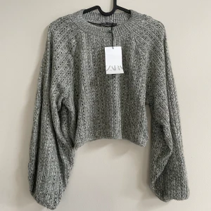 Stickad tröja från Zara - Jättefin tröja från Zara i nyskick! Tröjan är hålstickad och har ballongärmar. Den är kort i modellen. Den köptes för 259kr och har aldrig använts. Det är bara att skriva om du vill ha fler bilder eller har några funderingar!😊
