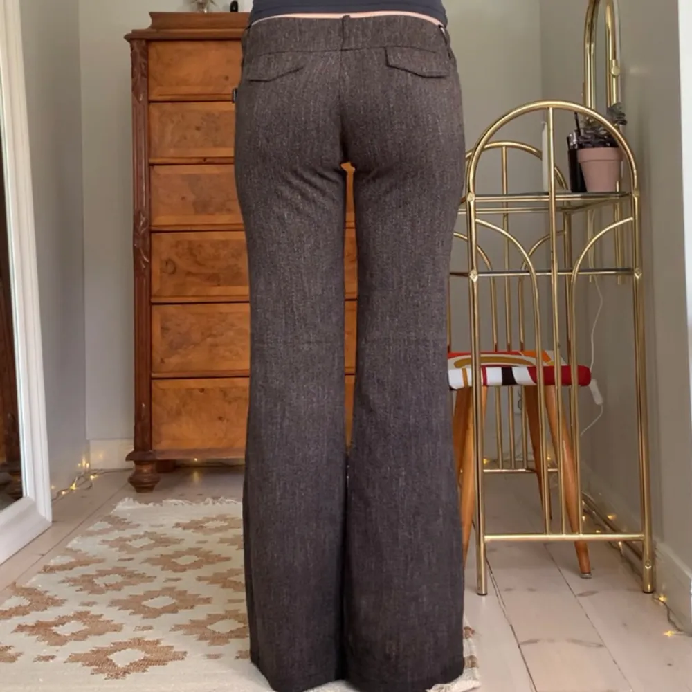 Lågmidjade utsvängda brungråa kostymbyxor från märket Top Trendy! Jag är 173 cm, midjemåttet är 76 cm och innerbenslängden 81 cm 🩷. Jeans & Byxor.
