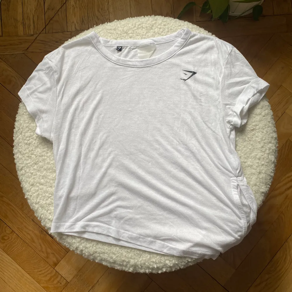 Gymshark t-shirt med knytning i sidan. Lappen med storlek är sliten så kan inte se storleken, men är 99% säker på XS. Lite nopprig.. T-shirts.
