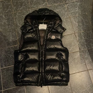 Moncler väst - Säljer min Moncler Bormes down gilet väst, köpt för cirka ett år sedan men jag har knappt använt den. Den är storlek 2(M) men sitter som S, skriv för fler bilder eller om du har någon fråga!
