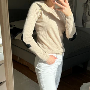Tröja från Zadig & Voltaire med coola detaljer - Snygg beige tröja i ull och kashmir med svarta detaljer på armbågarna. Sparsamt använd. 🫶🏼