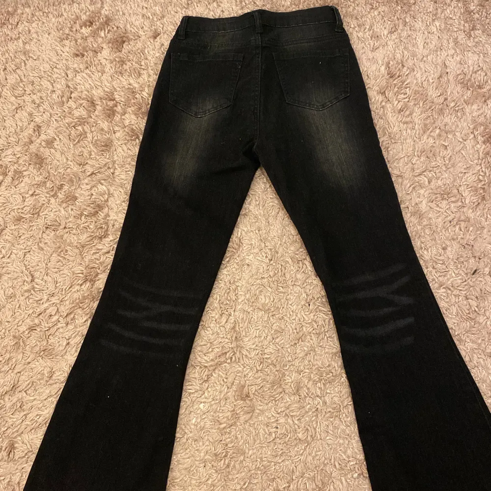 Ett par svarta bootcut jeans som är köpt från secondhand och aldrig använts. Jeans & Byxor.