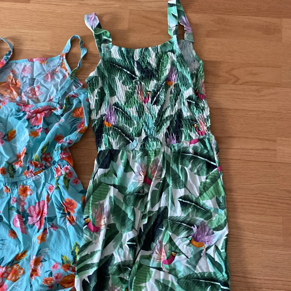 Tre stycken jumpsuits till barn. Den lila med citroner på är i storlek 170, den blåa med blommor är i storlek 164, den gröna med blommor är i storlek 170.. Toppar.