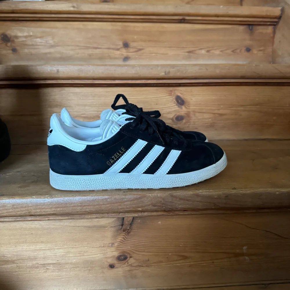 svarta adidas gazelle skor. Använda fåtal gånger. Den ända skadan är att texten på sulan i skon har skavts bort lite. . Skor.