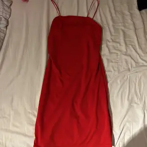 En fin, röd klänning med spagetti straps. Ganska kort, lite ovanför knäna. Storlek S. Använd 1 gång.