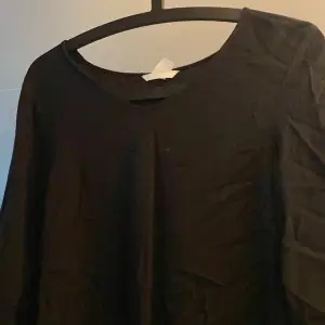 En svart blus med knytning vid ärmarna från hm 