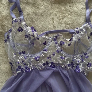Lila babydoll - Söt babydoll linne i spets och chiffong. Är justerbar både vid axlar och byst (övrerygg). Är i ljuslila material. Aldrig används, och är i storlek M. 