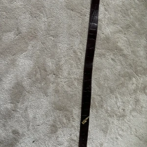 Skärp - Brunt skärp med guld detaljer  Storlek 75 Andvänt men lite slitet längst ner