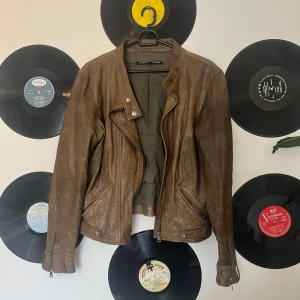 Brun skinnjacka - Fin vintage skinnjacka i bra skick!! Har flera söta detaljer och är i god kvalitet😊