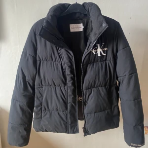 calvin klein jacka - mw non down short puffer jacka, nypris 2195kr. välanvänd men bra skick, en liten reva i ryggen (bild 4) men inget som märks/påverkar. jackan kommer med en luva som är borttagbar🤩pris går att diskutera, möts i örebro annars står köpare för frakt! 
