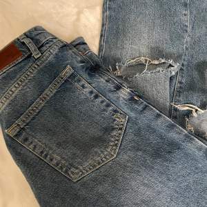Blå jeans med högre midja från BikBok. Dom har hål på knäna. Storlek:25