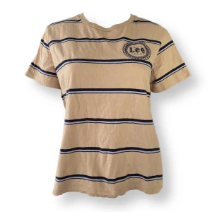 Lee Randig Tröja - Lee t-shirt i fint skick, storlek L. Finns ett litet hål som syns på sista bilden. Dockan använder storlek XS. MÅTT: Axel till axel 41cm, ärmlängd 17cm, armhåla till armhåla cirka 53cm & längd 56cm 