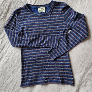 Glittertröja Mads Nørgaard  - Långärmad randig T-shirt i glitter. Storlek S dam. Modell "Tuba". Blå, vinröd, silver. Bra skick. Bomull, modal, lurex. 