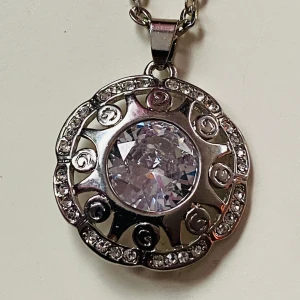 Halsband 18kgp - Vackert silverfärgat halsband med slipad rhinestone Berlock stämplad 18kgp  18 karat guldpläterat   Kedjan okänt material   Berlock 3,5 cm Kedjan 50 cm